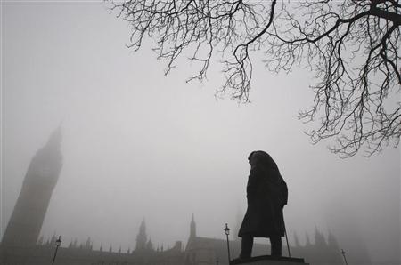 A statue of former British Prime Minister Winston Churchill is seen in front of the Houses of Parliament in morning mist at Parliament Square in central London